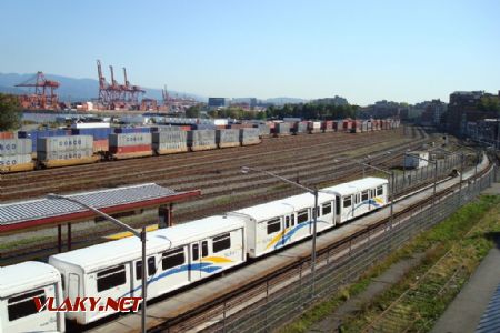 27.9.2009 - Vancouver, BC. Ďalšia súprava dvoch dvojvozňových jednotiek ''SkyTrain''. V pozadí severný kontajnerový prístav s príslušnými vozňami © Michal Stríž