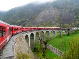 Elektrická jednotka Allegra tahne řadu osobních vozů pro japonské turisty a cisternu na viaduktu u Brusia	26.4.2013	 © 	Jan Přikryl