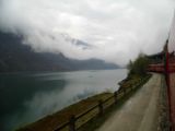 Dlouhý osobní vlak RhB jede na břehu jezera Lago di Poschiavo, cesta vedle trati kdysi bývala kantonální silnice	26.4.2013	 © 	Jan Přikryl