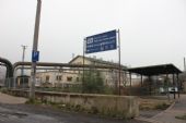 25.11.2014 - Ústí na Labem: směrovka k vlakům s přístřeškem zastávky MHD Západní nádraží a výpravní budovou v pozadí © PhDr. Zbyněk Zlinský