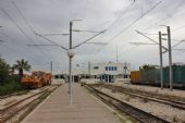 04.06.2016 - gare Mahdia: výpravní budova s podbíječkou 08-16 COMBI EMV na koleji 3 a nákladními vagony na koleji 4 © PhDr. Zbyněk Zlinský