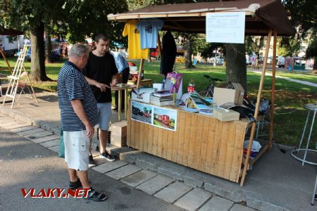 31.08.2019 - Hradec Králové, Smetanovo nábř.: stánek Společnosti železniční Výtopna Jaroměř a člen klubu VLAKY.NET ''Bulík'' se zákazníkem © PhDr. Zbyněk Zlinský