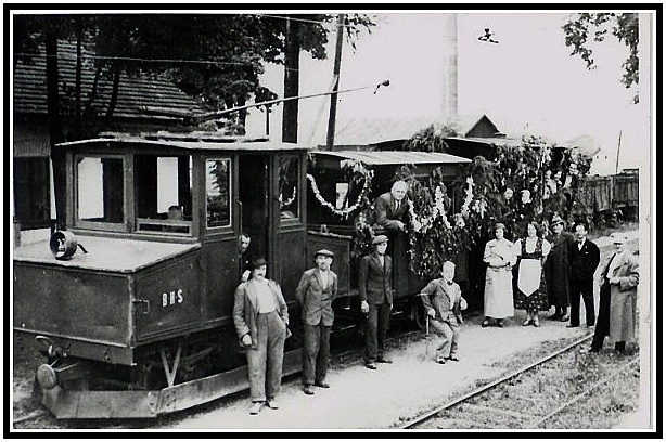 Elektrická lokomotíva AEG na markušovskej stanici v roku 1926. Na boku lokomotívy je zreteľný nápis B.H.S. označujúci majiteľa železnice- Banskú a hutnú spoločnosť. (archív Lukáš Patera)
